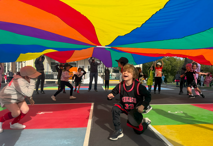 Students playing under colourful parachute during 2025 Sportathon.