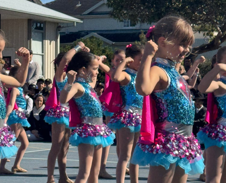 Years 1 & 2 dance troupe, wearing their blue and pink sparkly costumes performing at Education Week Assembly