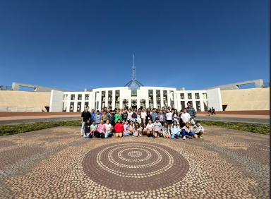 Year 6 group shot in front of Parliament House in Canberra.