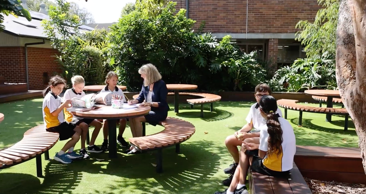 Teacher and 5 students in the outdoor learning area.