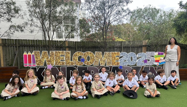 A kindergarten class with their teacher on the first day of school .