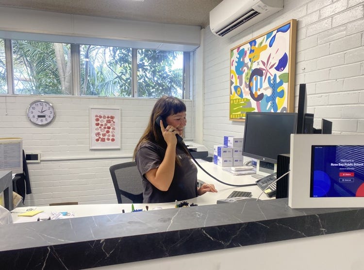 A female office staff member answering the phone in the office.